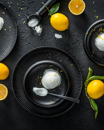 Zitronensorbet auf 3 schwarzen Tellern
