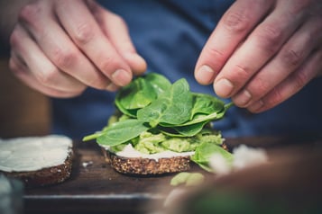 Sandwich wird mit Spinat belegt