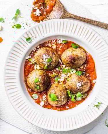 5 Hackfleischbällchen in Tomatensugo in einem weißen Teller