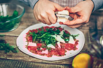 Parmesan wird auf dem Carpaccio verteilt
