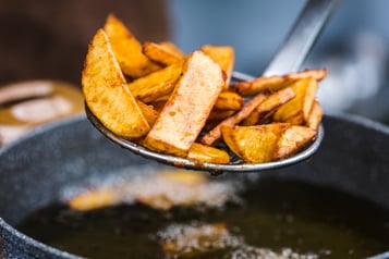 Belgische Pommes werden aus der Fritteuse genommen
