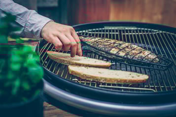 Brot und Fisch liegen auf einem Grill