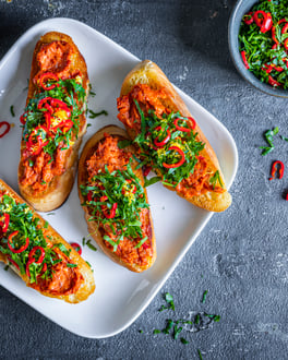 Crostini belegt mit Nduja auf dunklem Grund