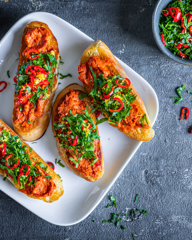 Crostini belegt mit Nduja auf dunklem Grund