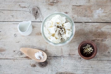 Eine Schüssel mit Feta steht auf Holzuntergund