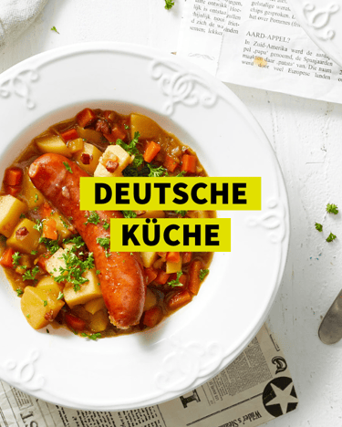 Ein Eintopf mit einer Wurst und Kartoffeln in einem weißen Teller