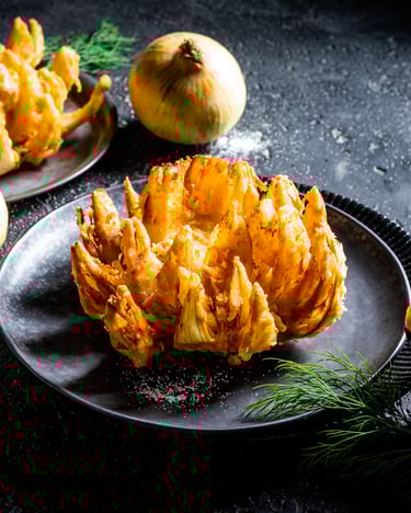 Auf einem schwarzen Teller liegt eine Blooming Onion.