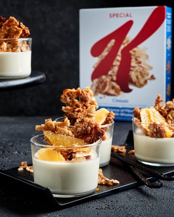 Kleine Dessertgläser mit Panna Cotta und Cornflakes Crunch drauf.