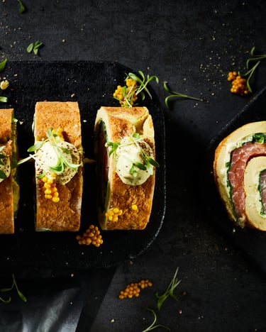 Eine angeschnittene Omelette-Rolle mit Räucherlachsfüllung vor dunklem Hintergrund