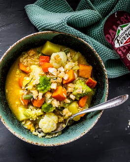 italienische Minestrone mit Reis in Suppenteller auf dunklem Untergrund