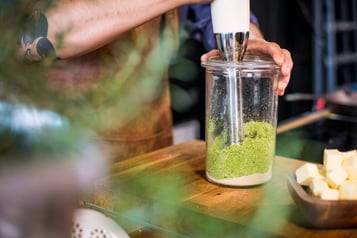 Zutaten in einem Glas werden mit einem Stabmixer püriert