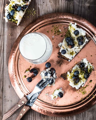 Stulle mit cremigem Ricotta, Heidelbeeren und Pistazien.