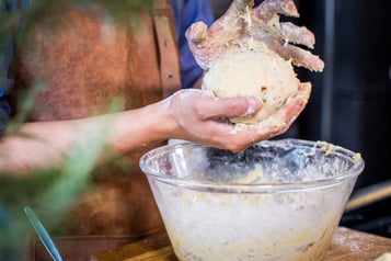 2 Hände formen einen Knödel über einer Glasschüssel
