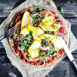 Vegane Blumenkohlpizza auf einem dunklen Holzuntergrund