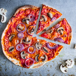 Pizza funghi auf grauem Untergrund