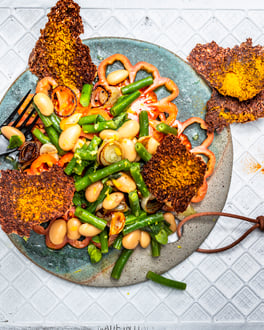 Salat mit grünen und weißen Bohnen auf Tomatenscheiben mit Leinsamen-Cracker von oben fotografiert