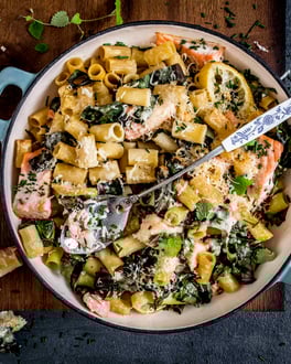 Nudelauflauf in einer Pfanne mit Lachs und Spinat.