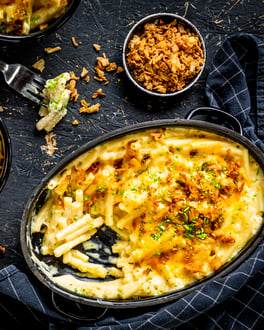 Mac'n'Cheese in einer Auflaufform auf schwarzem Untergrund