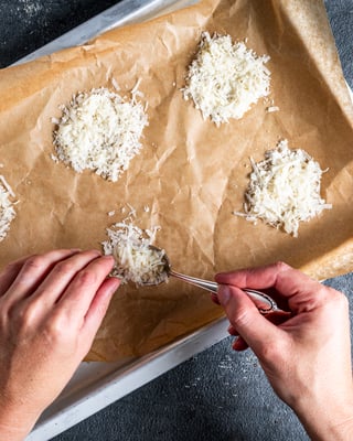 geriebener Parmesan wird kreisrund auf Backblech gegeben