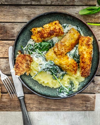 Fischstäbchen auf Kartoffelbrei mit Rahmspinat.