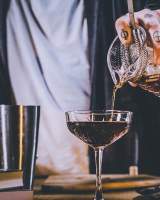 Einfüllen des White Russian mit Hilfe eines Strainers.