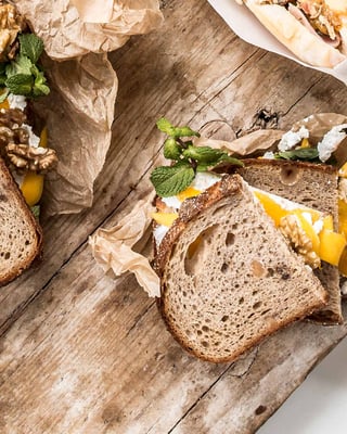 Ziegenkäsestulle mit Mango und Basilikum auf einem Holzbrett.