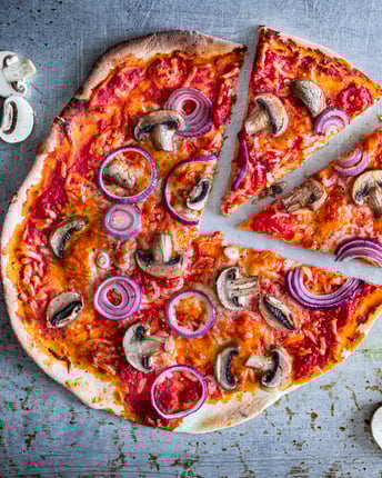 Pizza funghi auf grauem Untergrund