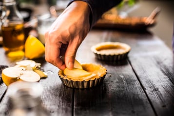 Apfelscheiben werden auf den Tarte-Teig gegeben.