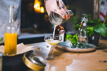 Den Hawaiian Cocktail wird mit einem Strainer in eine Cocktailschale abgeseiht.