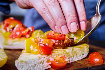Ciabatta wird mit bunten Tomaten belegt