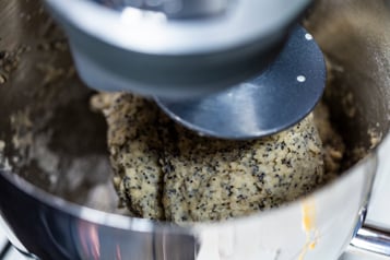 Küchenmaschine mit hellem Teig mit Mohn