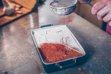 Kakao-Zimt-Mischung-auf-Tiramisu-geben
