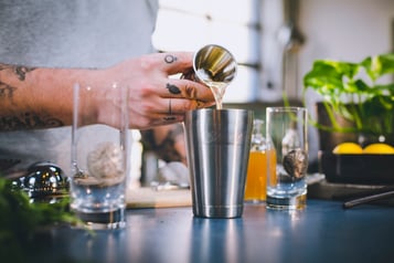 Zitronensaft wird für die Rucola-Limonade in den Shaker gegeben.