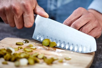 Cornichons kleinschneiden und über den Dip geben.
