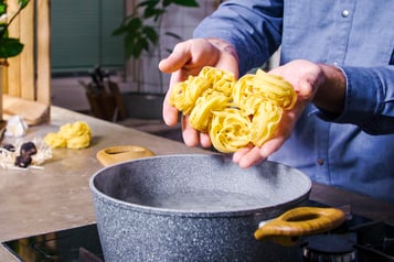 Tagliatelle über einem Topf mit Wasser