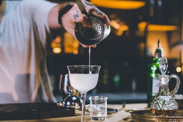 Drink mit einem Barsieb abseihen
