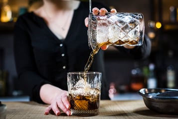 Drink in einen Tumbler abseihen