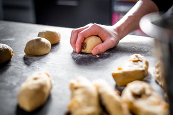 Die Hot Cross Buns werden von Hand zu Kugeln geformt.