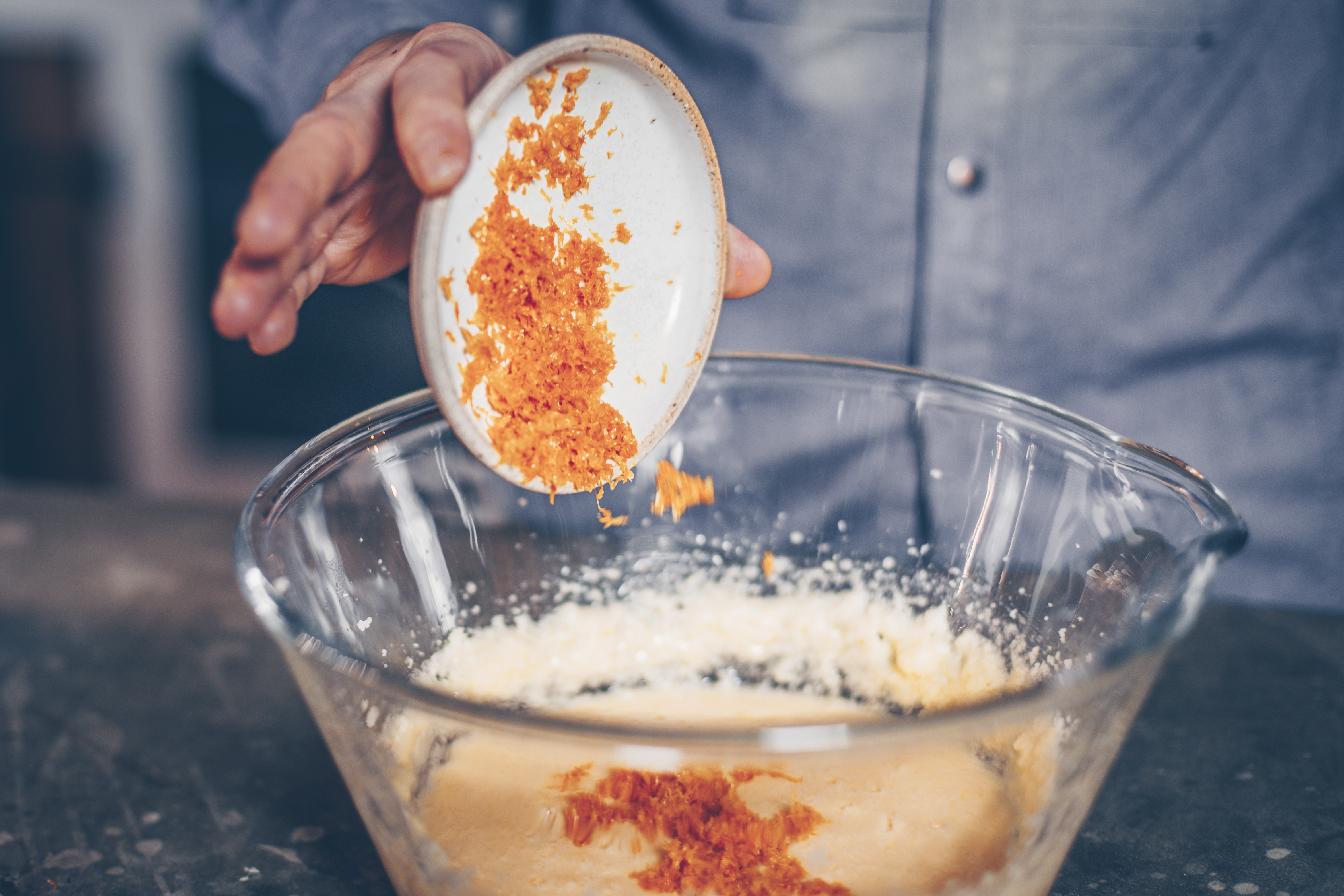 Orangenabrieb für Torta all'arancia wird in angerührten Teig gegeben