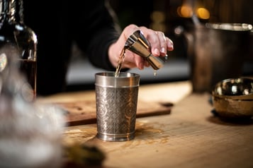 Zutaten mit dem Jigger in den Becher geben