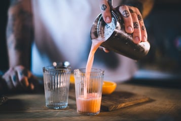 Aperol Sour mit dem Strainer ins Glas giessen.
