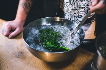 Dill wird in einer Schale mit Eiswasser abgeschreckt.