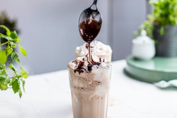 Glas mit Espressocreme, Schlagsahne und Schokosauce.