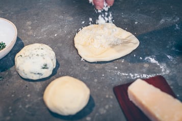 Parmesan wird auf Teig für die Grissini gestreut