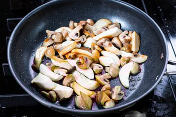 Champignons und Kräuterseitlinge in einer Pfanne anbraten