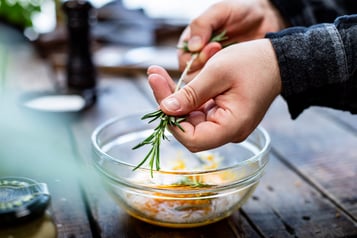 Rosmarinspitzen abzupfen und in die Marinade geben.