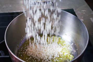 Risottoreis zu Schalotte und Olivenöl in Topf geben