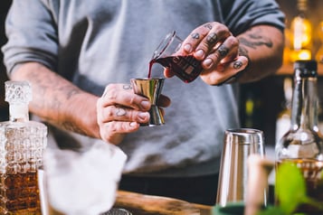 Grenadinesaft für den Jack Rose Cocktail wird in den Jigger gefüllt.