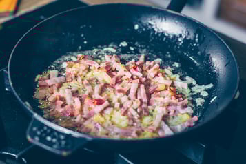 Speck und Zwiebeln werden in einer Pfanne für Rösti trentino  angeschiwtzt