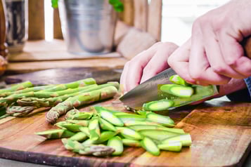 Grüner Spargel wird schräg für die Tortellini geschnitten